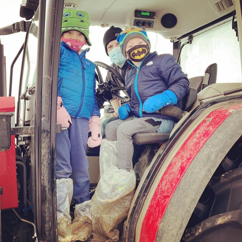 two children and a man in a tractor