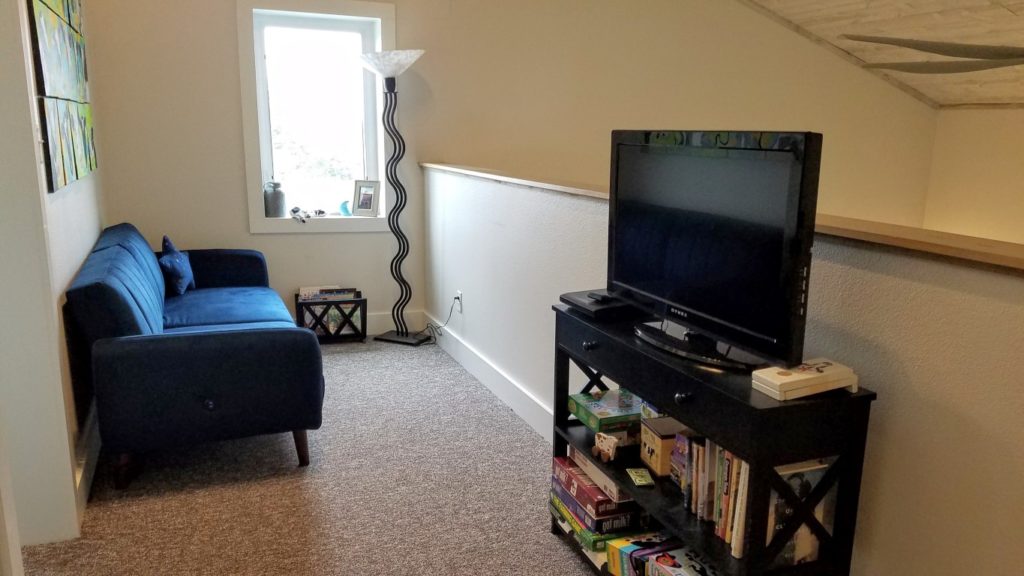 blue couch in loft area with a tv nearby