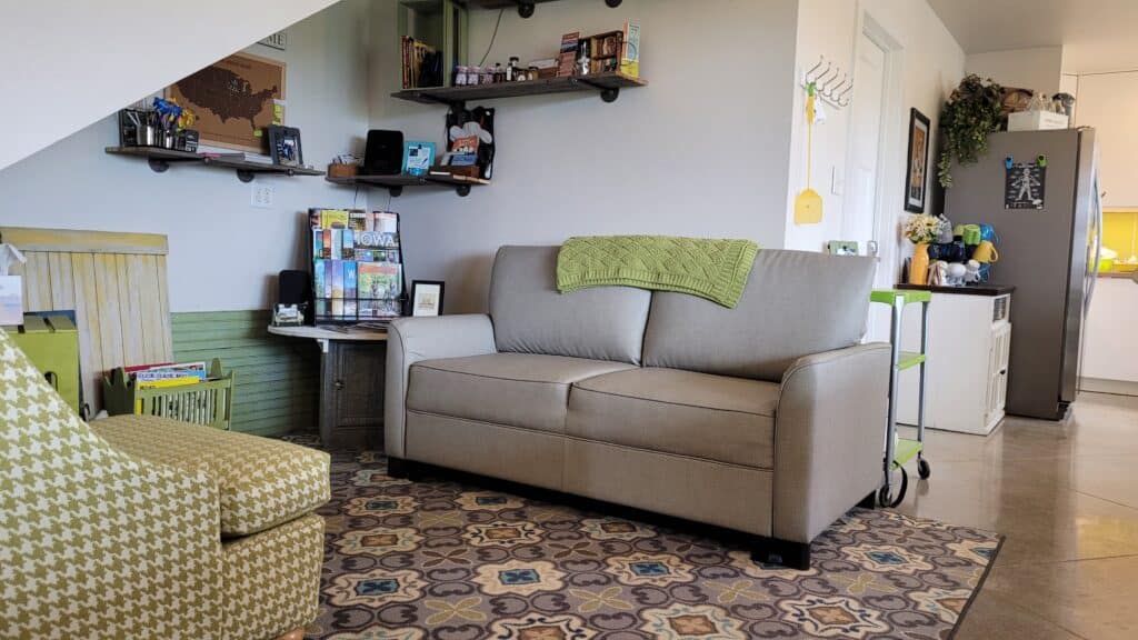 living room by the kitchen with a gray couch and lime green checkered chair