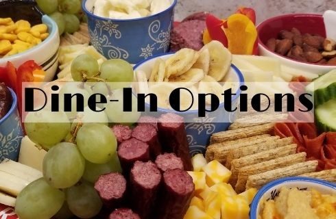meat, cheese, crackers, fruit arranged on a chartcuterie borad