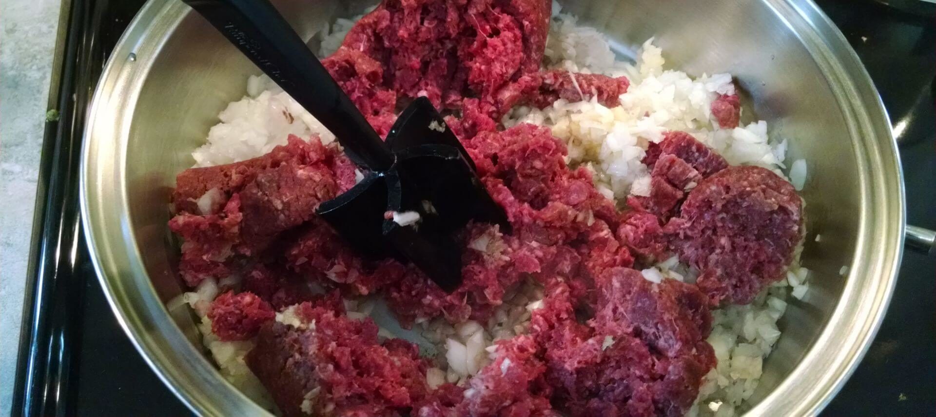 Ground Beef with Onion being Browned in a Stainless Steel Pan