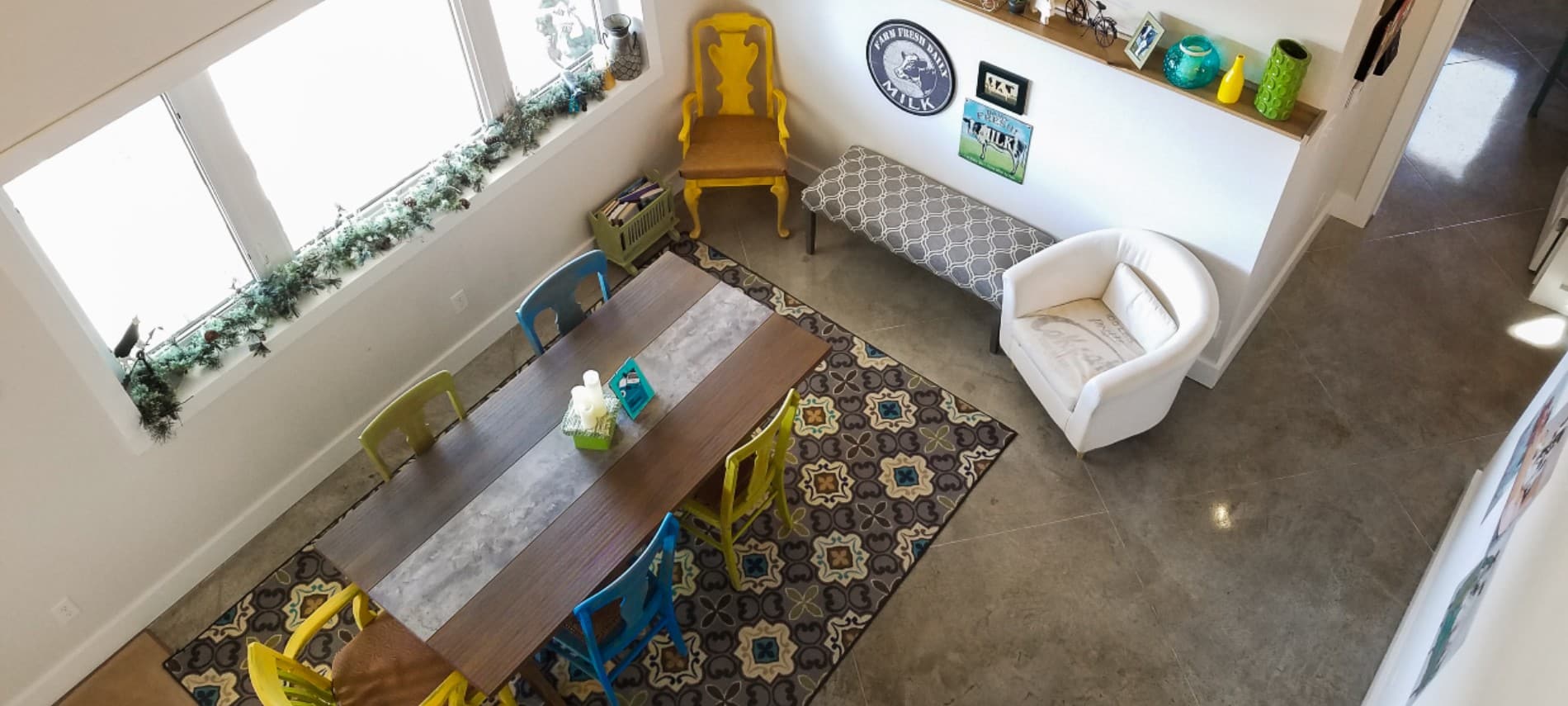 Looking down over a table with chairs & a bench around it