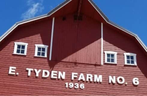 Close up view of large red barn with E Tyden Farm No. 6 1936 text in white