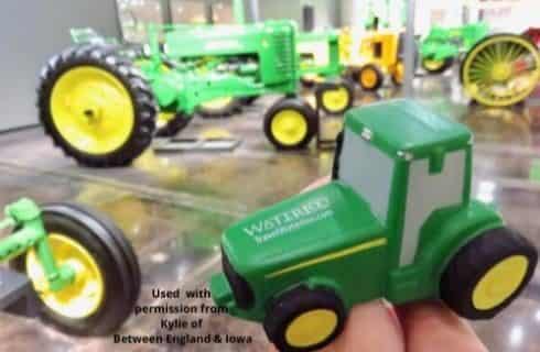 Regular sized old green and yellow tractors and a toy sized green and yellow tractor