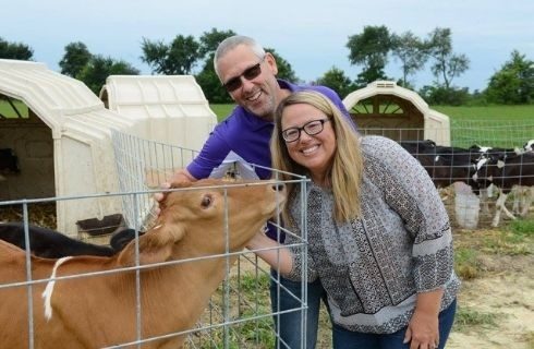 Man and Woman petting brown calf