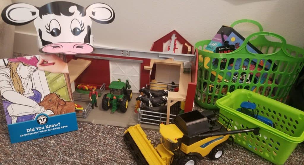 toy barn with toy tractors, coloring book, and cow hat