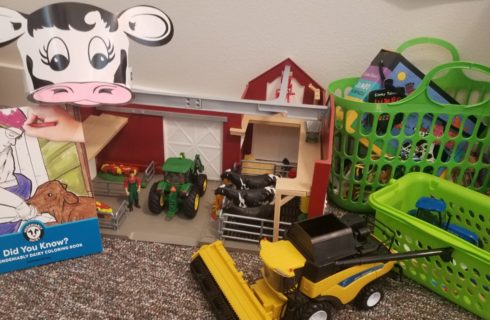 toy barn with toy tractors, coloring book, and cow hat