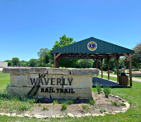 Trailhead sign for Bike Trail with picnic shelter behind